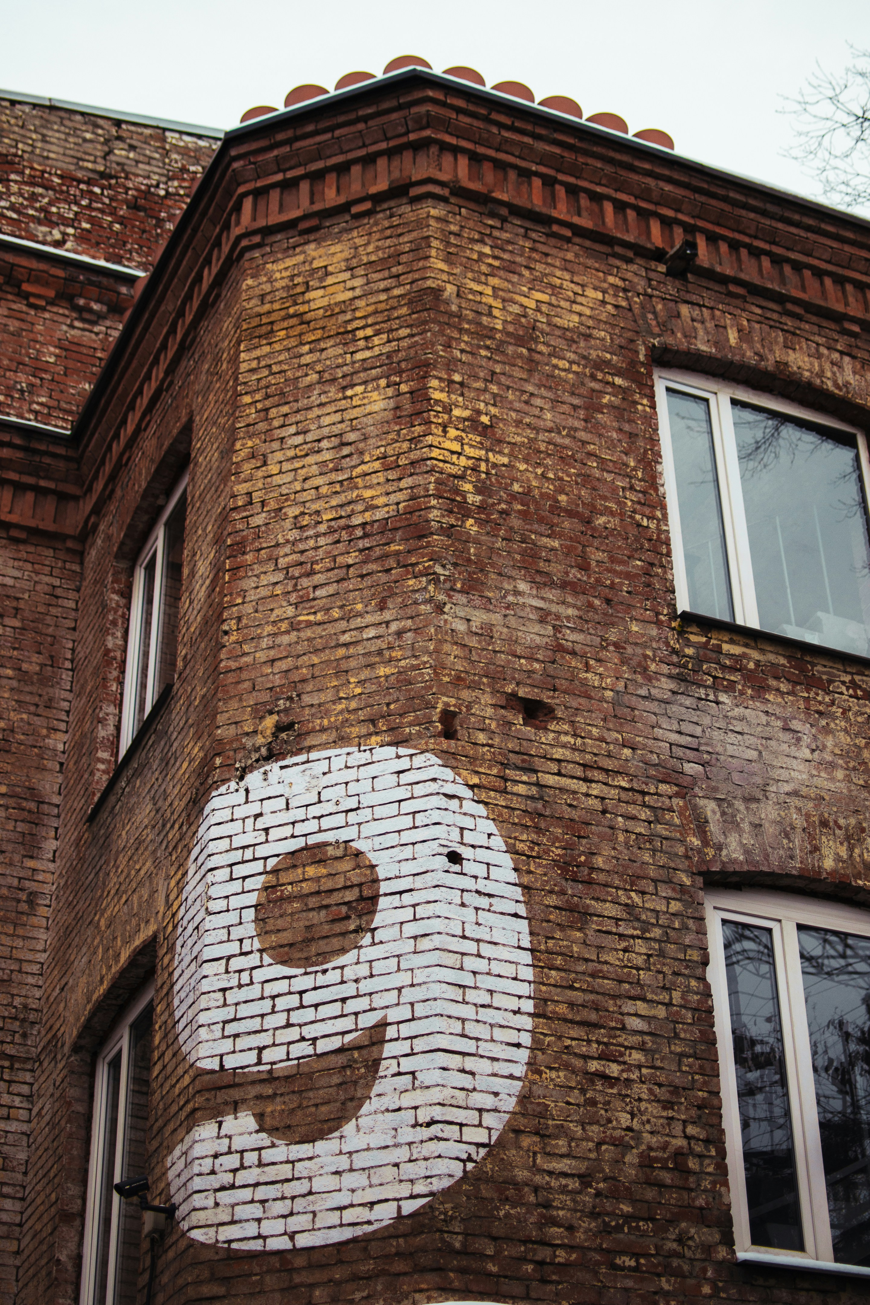 The number 9 in white paint on a brick building